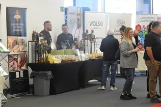 Obrazek przedstawia stoisko wystawiennicze podczas konferencji