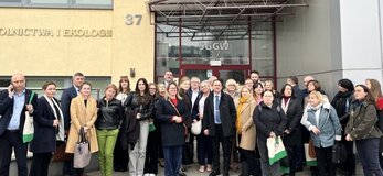 Grupa osób przed budynkiem SGGW