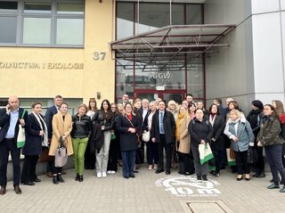 Grupa osób przed budynkiem SGGW