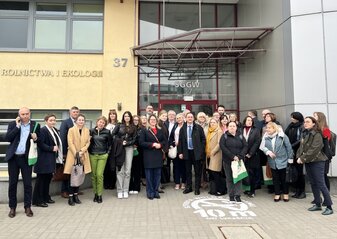 Grupa osób przed budynkiem SGGW