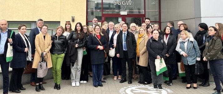 Grupa osób przed budynkiem SGGW