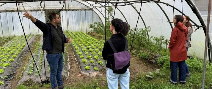 Obrazek przedstawia uczestników spotkania w szklarni