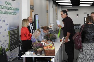 Obrazek przedstawia stoisko wystawiennicze podczas konferencji