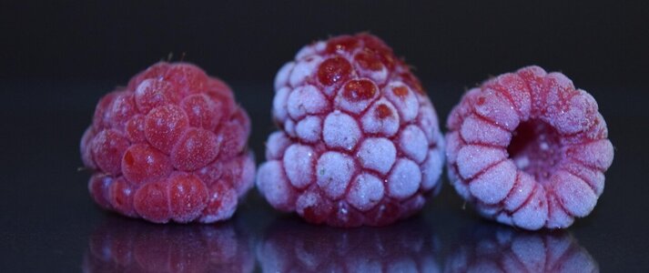 Obrazek przedstawia trzy mrożone maliny