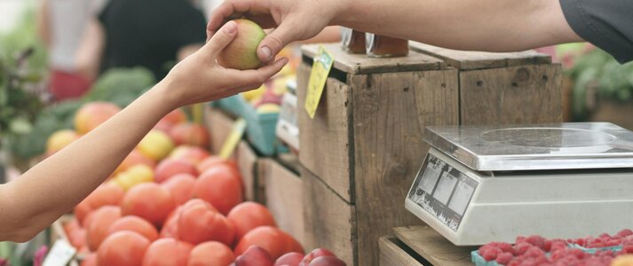 zdjęcie przedstawia podanie jabłka z ręki do ręki