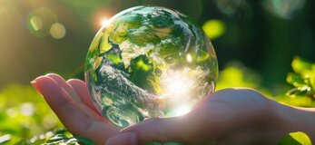 Zdjęcie przedstawia rękę trzymająca kulę ziemską