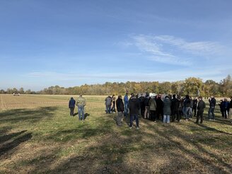 Obrazek przedstawia uczestników pokazu maszyn na polu