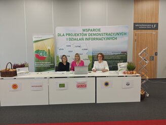 Obrazek przedstawia staoisko wystawiennicze podczas konferencji