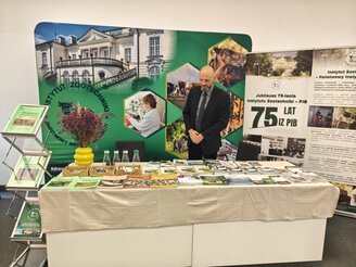 Obrazek przedstawia stoisko wystawiennicze podczas konferencji