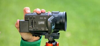 Zdjęcie przedstawia rękę trzymającą kamerę