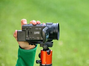 Zdjęcie przedstawia rękę trzymającą kamerę