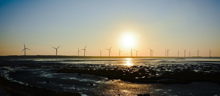 Zdjecie przedstawia wiatraki o zachodzie słońca