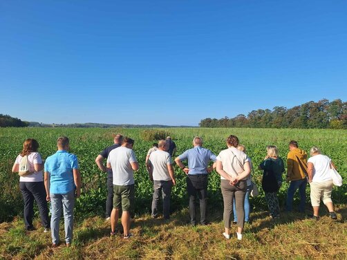 Zdjęcie przedstawia uczestników konferencji podczas wizyty studyjnej w gospodarstwie rolnym