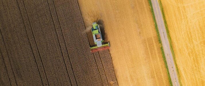 Obrazek przedstawia kombajn na polu z lotu ptaka. 