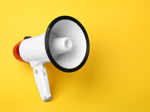 Electronic megaphone on color background